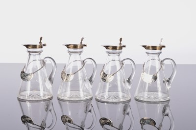 Lot 214 - A nice set of four George V period glass and silver Whisky water jugs by Hukin & Heath