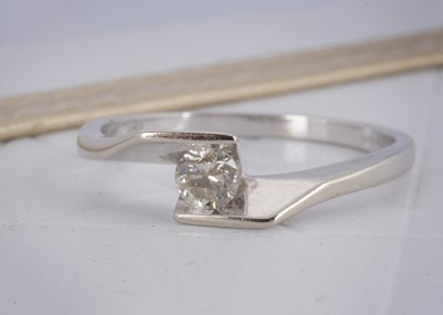 Lot 15 - An 18ct gold diamond crossover solitaire dress ring