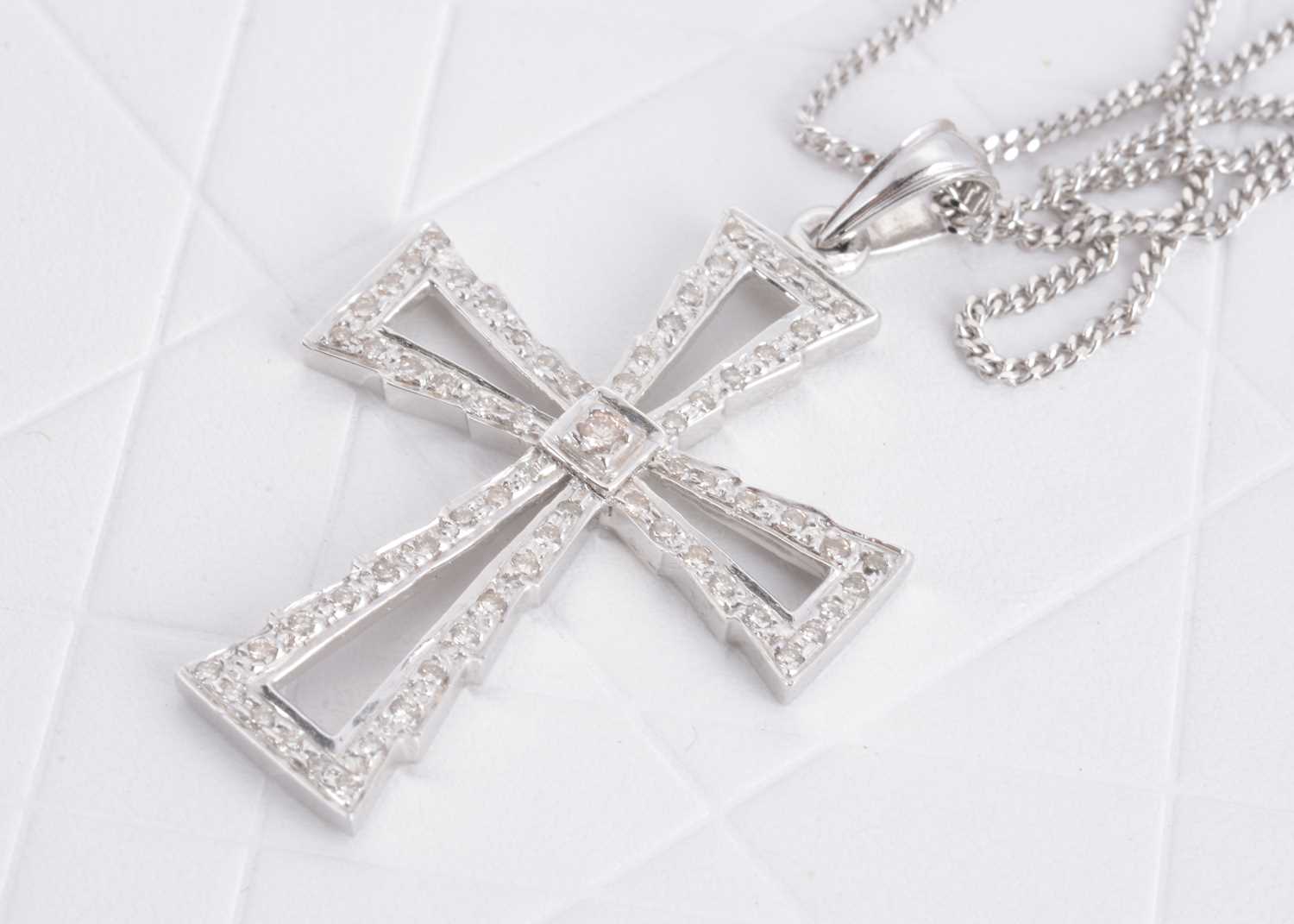 Lot 124 - A contemporary 9ct white gold and diamond set cross pendant