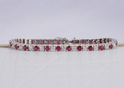 Lot 151 - A continental 750 marked white metal ruby and diamond tennis bracelet