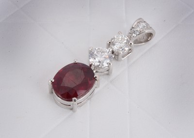 Lot 153 - A 750 marked white metal ruby and diamond drop pendant