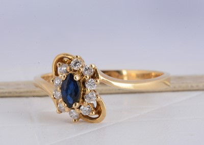 Lot 155 - A 750 marked yellow metal sapphire and diamond cluster crossover ring