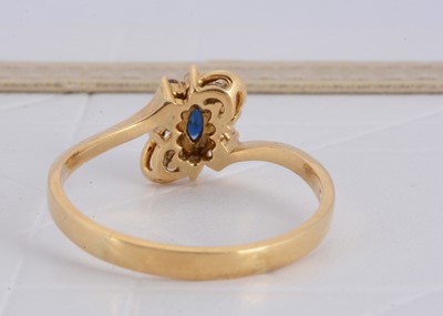 Lot 155 - A 750 marked yellow metal sapphire and diamond cluster crossover ring