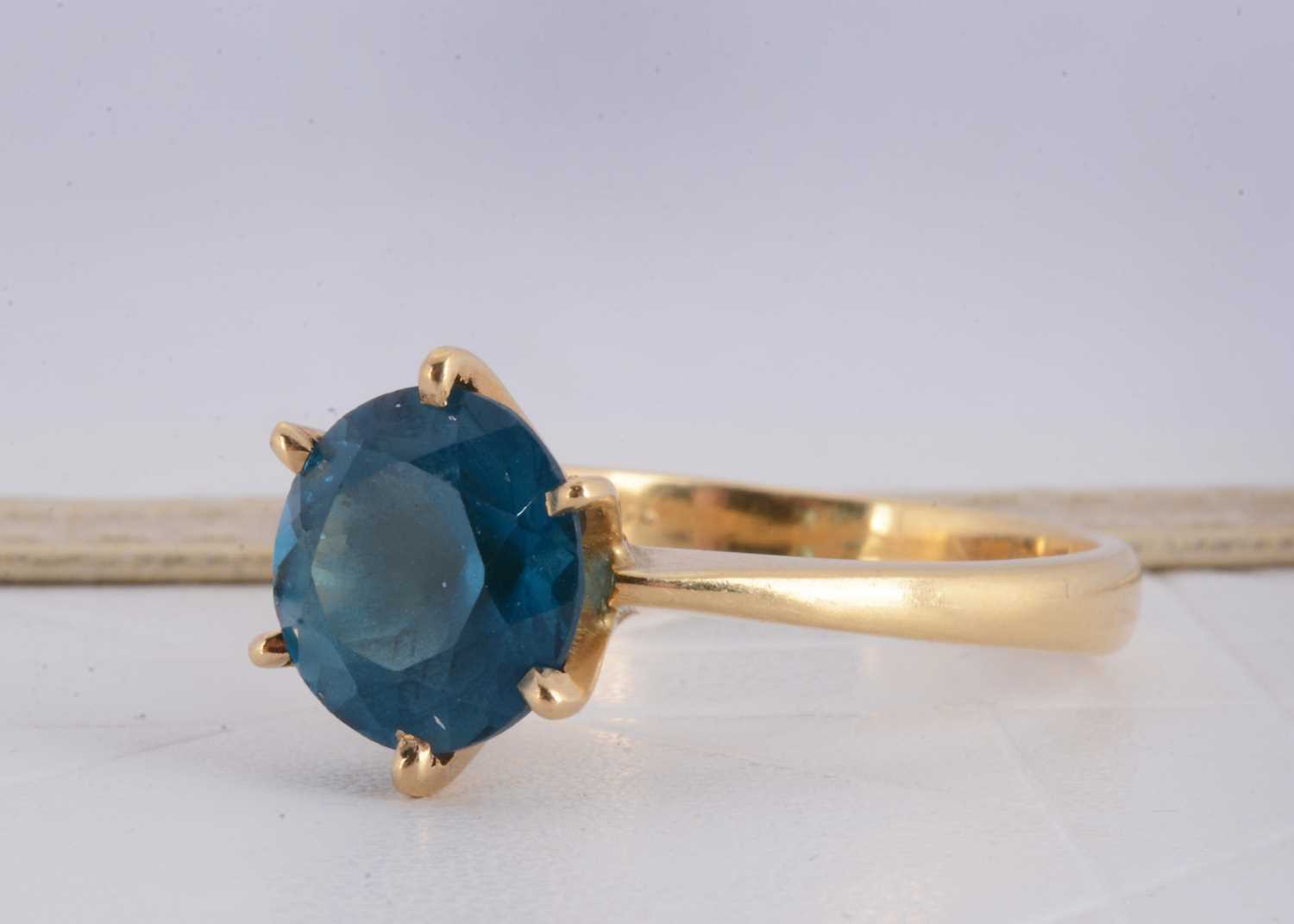 Lot 156 - A continental 750 marked yellow metal blue topaz dress ring