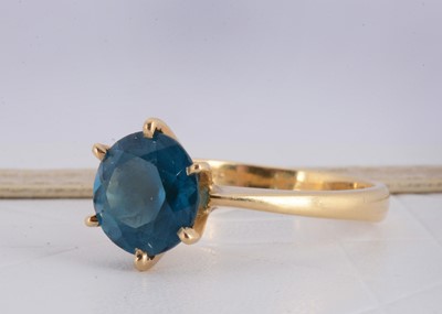 Lot 156 - A continental 750 marked yellow metal blue topaz dress ring