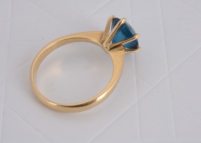 Lot 156 - A continental 750 marked yellow metal blue topaz dress ring