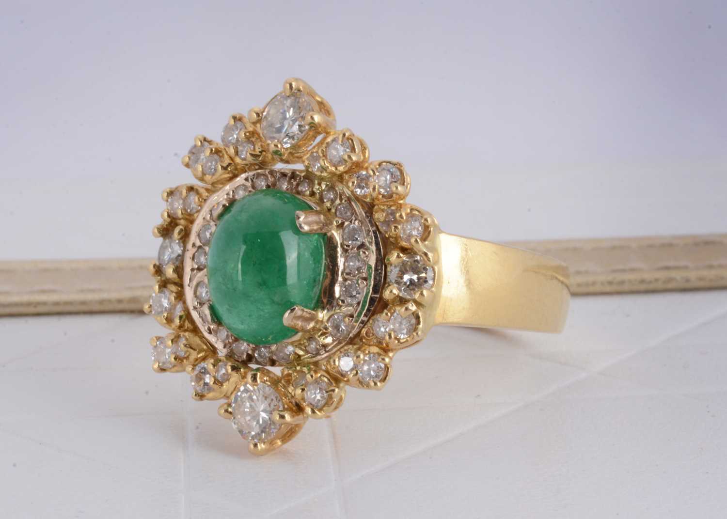 Lot 157 - A continental yellow metal emerald and diamond dress ring