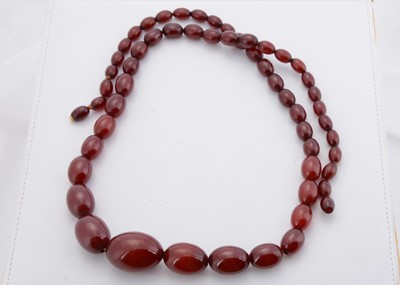 Lot 175 - A long string of 'cherry amber' beads