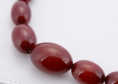 Lot 175 - A long string of 'cherry amber' beads