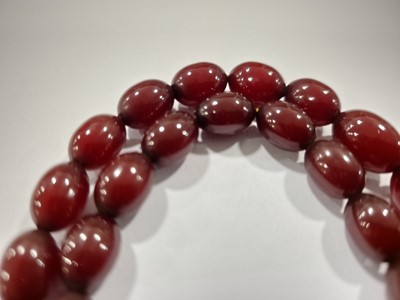 Lot 175 - A long string of 'cherry amber' beads