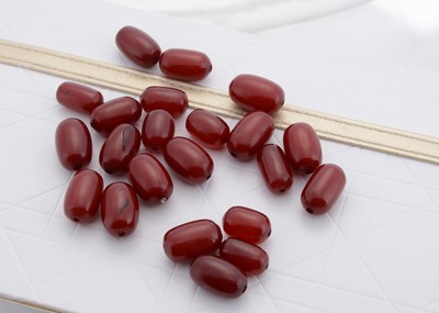 Lot 180 - A collection of 'cherry amber' oval beads