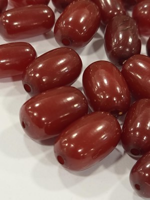 Lot 180 - A collection of 'cherry amber' oval beads