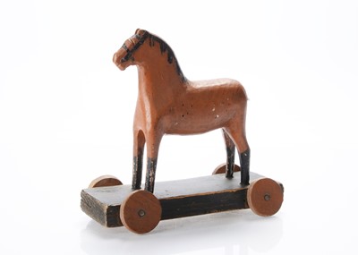 Lot 656 - A primitive carved wooden Folk Art horse on wheels
