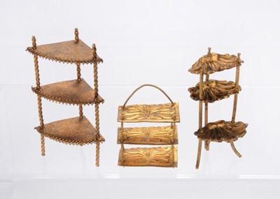Lot 1020 - Three gilt metal dolls’ house what-nots