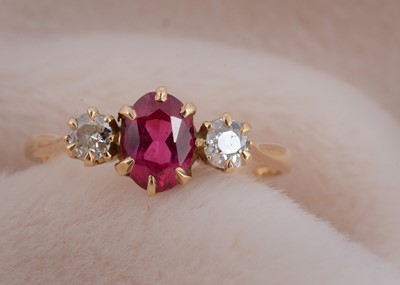 Lot 28 - A three stone ruby and diamond dress ring