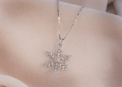 Lot 114 - A 9ct gold diamond set snowflake designed pendant