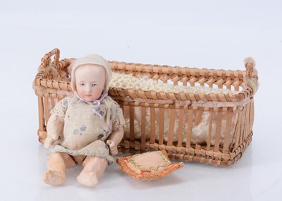 Lot 821 - A smaller Gebruder Heubach baby in original wicker crib