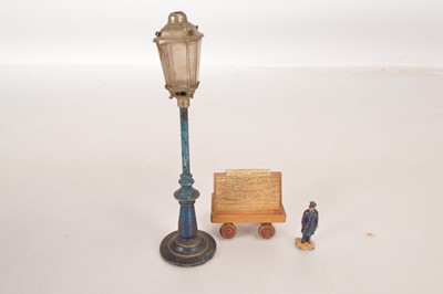 Lot 714 - An early Bing Lamp Column with wooden Station Newspaper Trolley and Hornby person (3)