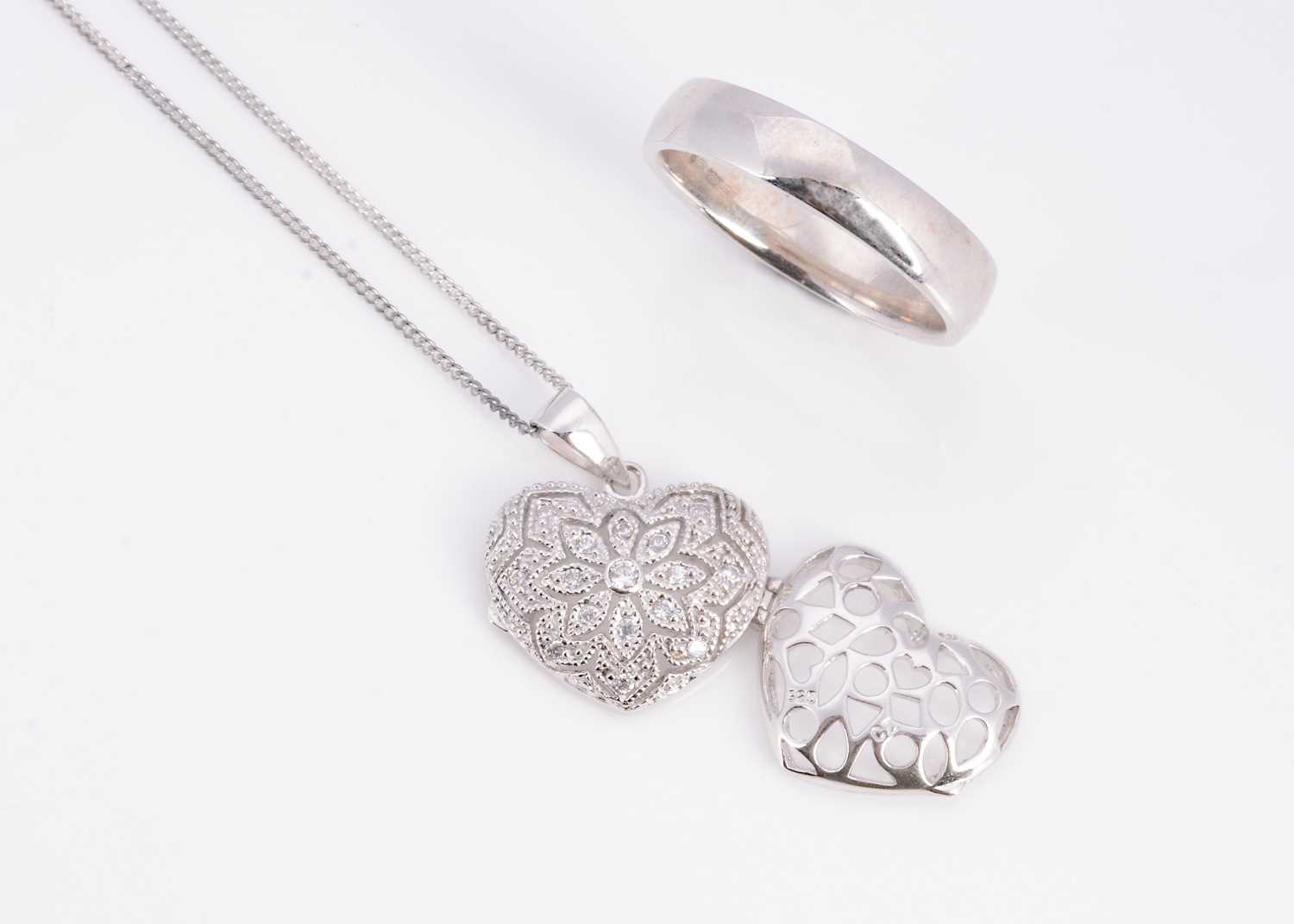 Lot 16 - An silver wedding band, a silver pave set CZ heart pendant on chain
