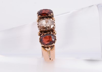 Lot 84 - A 9ct rose gold three stone garnet dress ring