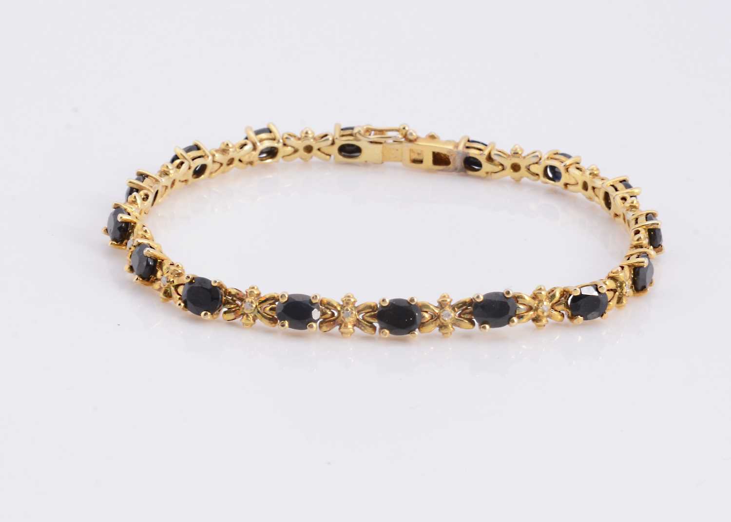 Lot 95 - A silver gilt sapphire set line bracelet