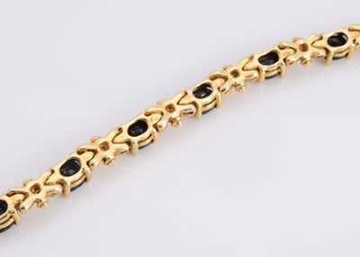 Lot 95 - A silver gilt sapphire set line bracelet