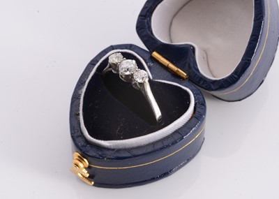 Lot 155 - A three stone white metal diamond dress ring
