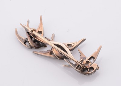 Lot 221 - A white metal three swallows in flight, diamond set brooch