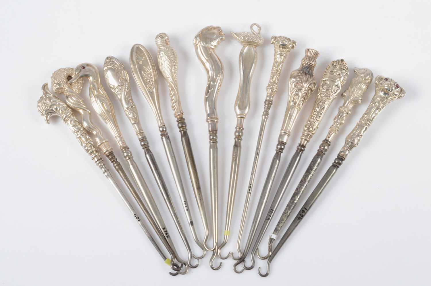 Lot 282 - Thirteen novelty silver handled button hooks