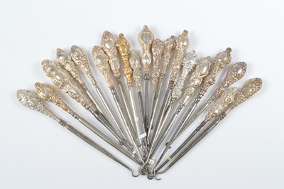 Lot 303 - A collection of silver handled embossed decorated steel button hooks