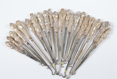 Lot 304 - A collection of silver handled embossed decorated steel button hooks