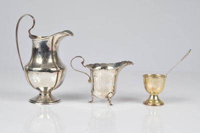 Lot 344 - Two silver milk jugs and an egg cup and spoon
