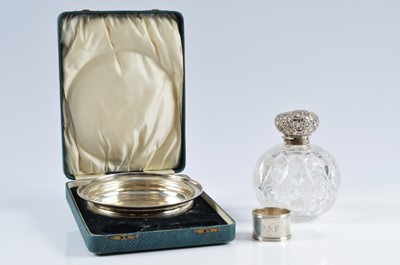 Lot 423 - A silver christening dish and a napkin ring and a damaged silver topped cut glass scent bottle